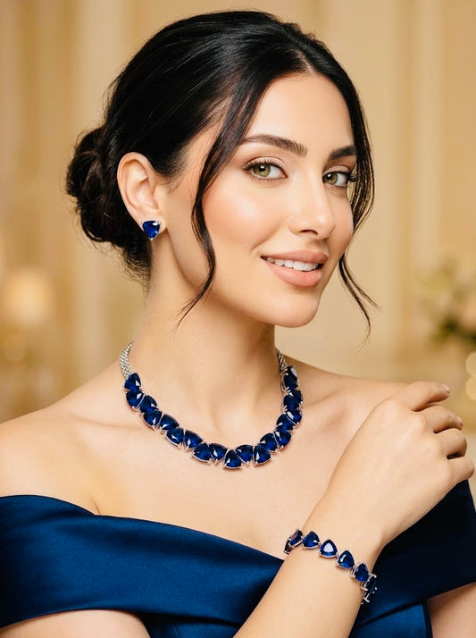 Model wearing the trillion-cut cubic zirconia necklace, earring and bracelet set in sapphire blue