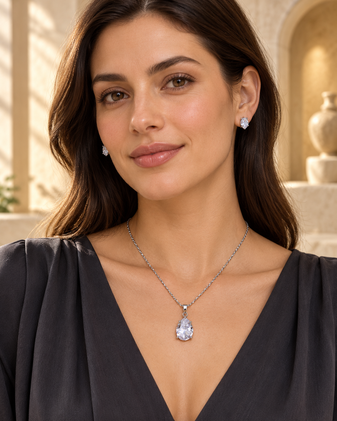 Model wearing pear solitaire chain pendant and stud set in White with Silver-tone finish