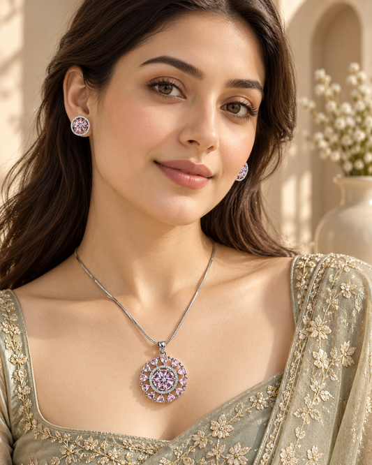 Model wearing round sunburst chain pendant and stud set in Pink with Silver-tone finish